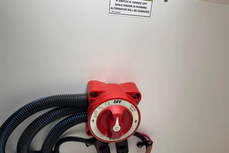 Slide: The Image of Red battery switch on 2026 Bayliner D22 boat with warning label above. - 40
