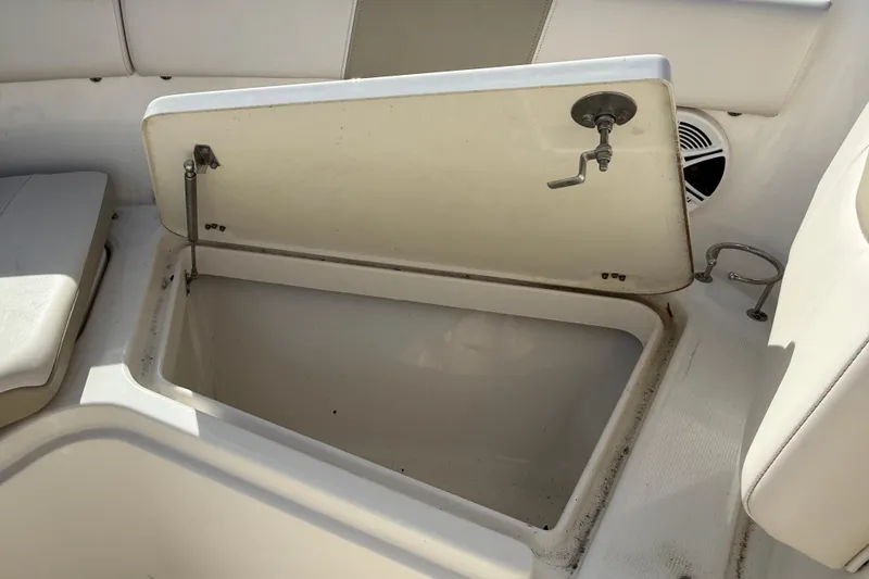 Slide: The Image of 2026 Robalo R277 Dual Console storage compartment with open lid and seating area. - 10