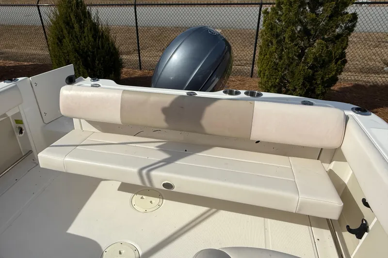 Slide: The Image of 2026 Robalo R277 Dual Console boat interior with cushioned seating and cup holders. - 11