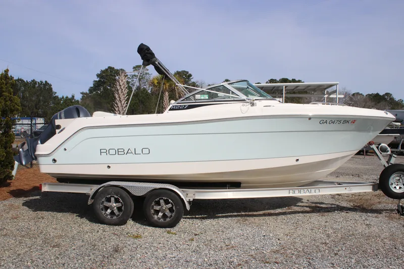 Slide: The Image of 2026 Robalo R277 Dual Console boat on trailer, side view. - 2