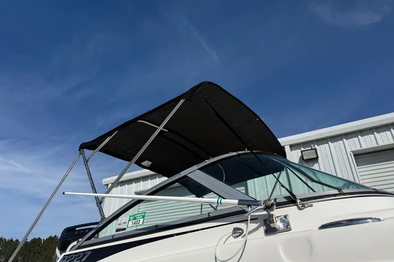 Slide: The Image of 2026 Robalo R277 Dual Console boat with black canopy against blue sky. - 20