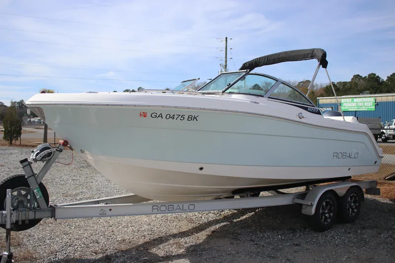 Slide: The Image of 2026 Robalo R277 Dual Console boat on trailer, side view. - 3
