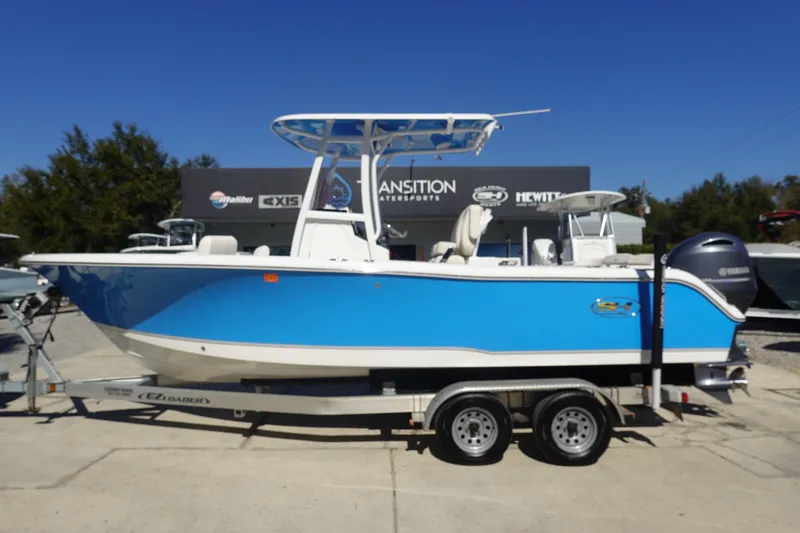 The Image of 2022 Sea Hunt Ultra 234 boat in vibrant blue on a trailer, outdoor display. - 1