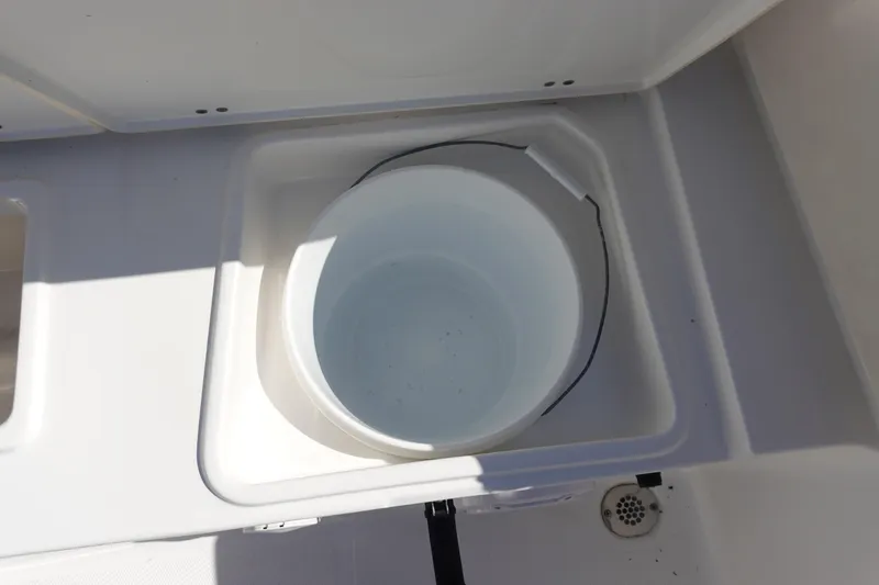 Slide: The Image of White bucket in storage compartment of 2022 Sea Hunt Ultra 234 boat. - 11