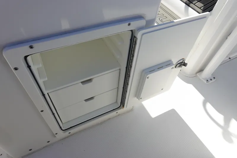 Slide: The Image of Storage compartment on 2022 Sea Hunt Ultra 234 boat, featuring two white drawers. - 18