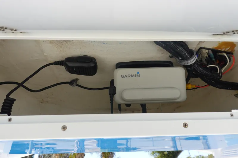 Slide: The Image of 2022 Sea Hunt Ultra 234 electronics compartment with Garmin device and wiring. - 24