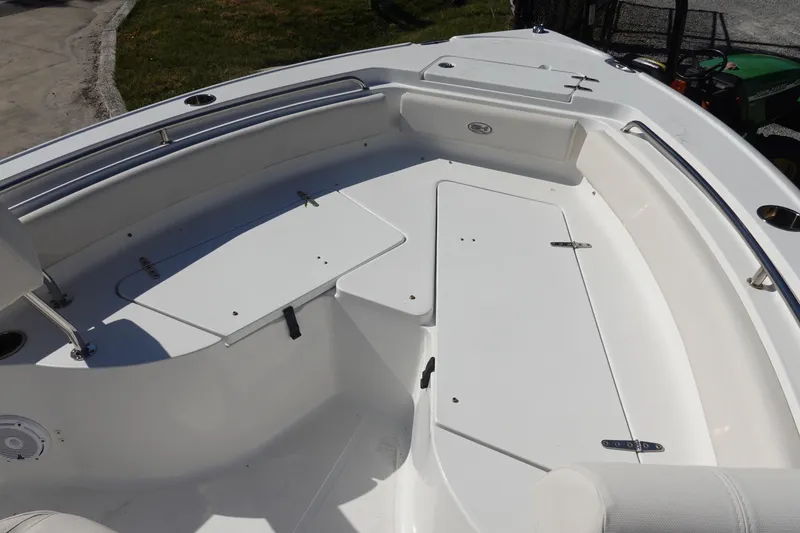 Slide: The Image of 2022 Sea Hunt Ultra 234 boat interior with white seating and storage compartments. - 29