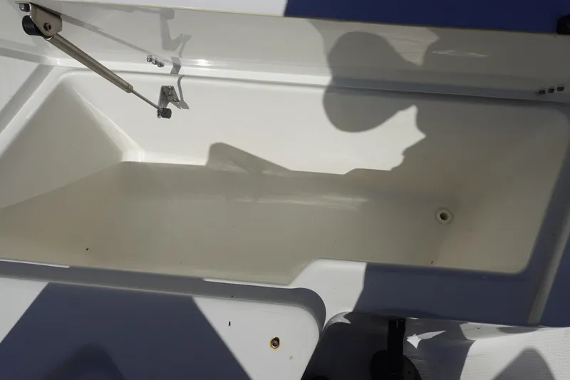 Slide: The Image of Open storage compartment on 2022 Sea Hunt Ultra 234 boat, showing interior details. - 32