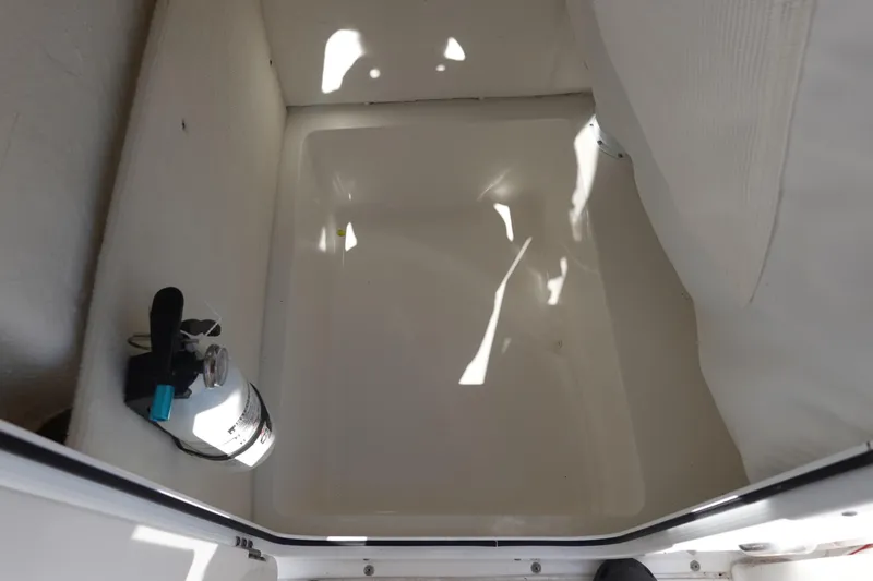 Slide: The Image of Storage compartment in a 2022 Sea Hunt Ultra 234 boat with fire extinguisher. - 35