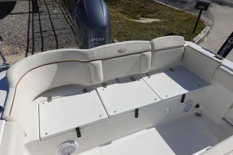 Slide: The Image of 2022 Sea Hunt Ultra 234 boat interior with cushioned seating and storage compartments. - 7