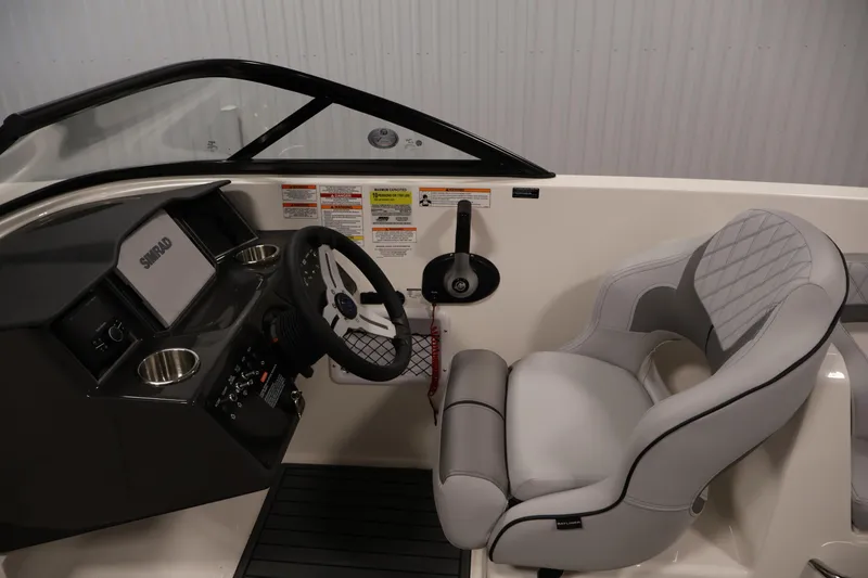 Slide: The Image of 2026 Bayliner VR6 Bowrider I/O cockpit with steering wheel and cushioned seat. - 13