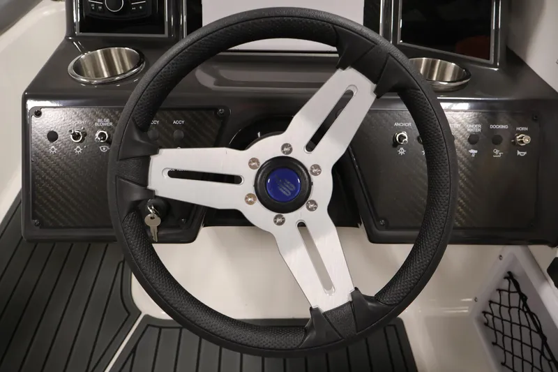 Slide: The Image of Steering wheel of 2026 Bayliner VR6 Bowrider I/O with control panel and cup holders. - 15