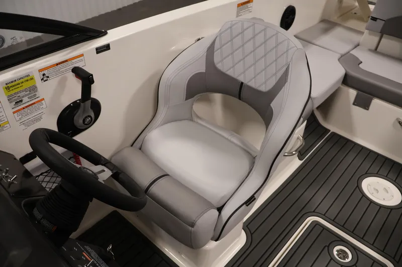 Slide: The Image of 2026 Bayliner VR6 Bowrider I/O cockpit with steering wheel and cushioned seat. - 23