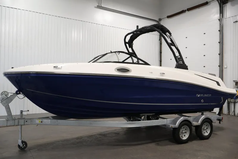 Slide: The Image of 2026 Bayliner VR6 Bowrider I/O boat on trailer in indoor setting. - 7