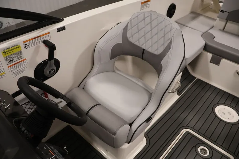Slide: The Image of 2026 Bayliner VR6 Bowrider I/O cockpit with steering wheel and cushioned seat. - 28
