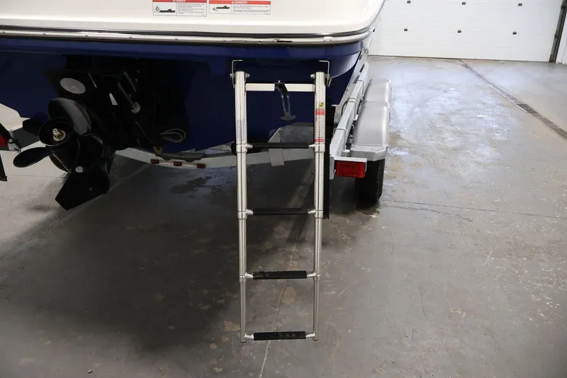 Slide: The Image of Rear view of 2026 Bayliner VR6 Bowrider I/O with ladder and trailer in a garage. - 44