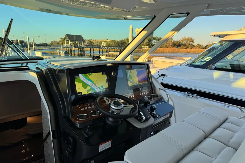 Slide: The Image of 2025 Tiara Yachts 38 LS helm with advanced navigation system, docked at marina. - 11
