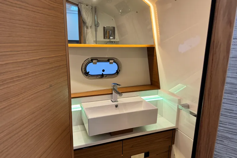 Slide: The Image of Luxurious bathroom interior of 2025 Tiara Yachts 38 LS with modern sink and porthole window. - 14