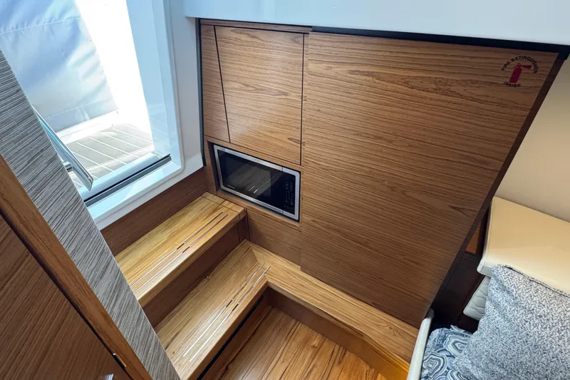 Slide: The Image of Interior of 2025 Tiara Yachts 38 LS with wooden stairs and built-in microwave. - 20