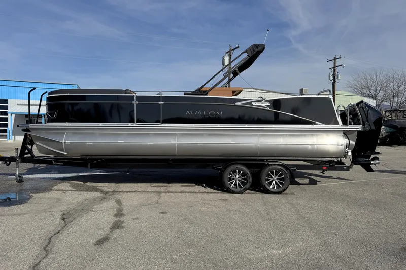 The Image of 2026 Avalon 2585 25 Catalina ENT pontoon boat on trailer, parked outdoors. - 0