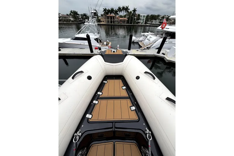 Slide: The Image of 2025 Brig NAVIGATOR22 boat docked at marina, featuring sleek design and wooden deck. - 14