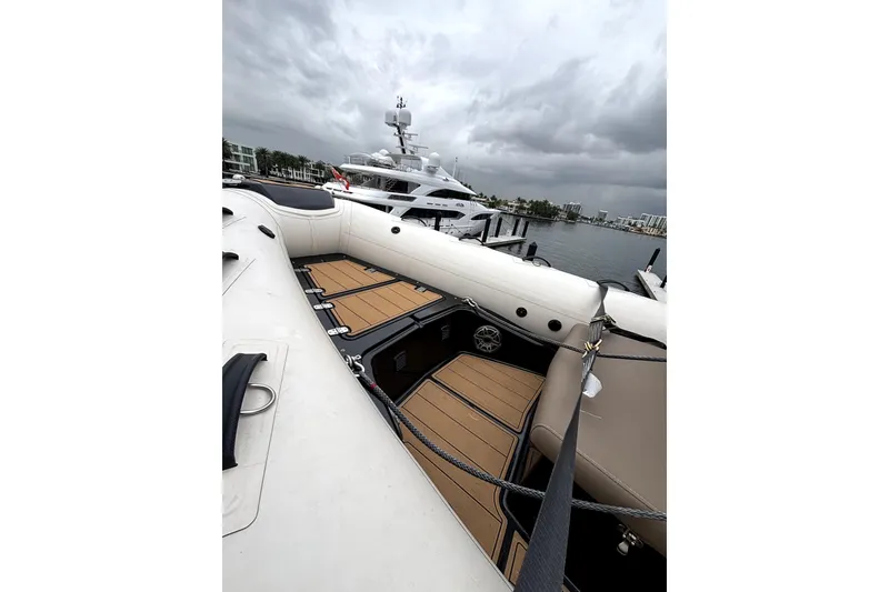 Slide: The Image of 2025 Brig NAVIGATOR22 boat interior with wooden deck, docked under cloudy skies. - 15