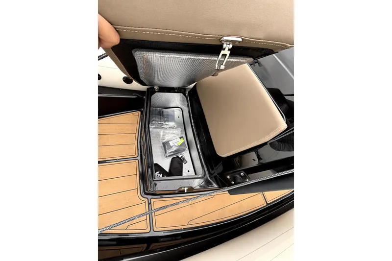 Slide: The Image of 2025 Brig NAVIGATOR22 boat storage compartment with beige seat and wooden deck. - 19