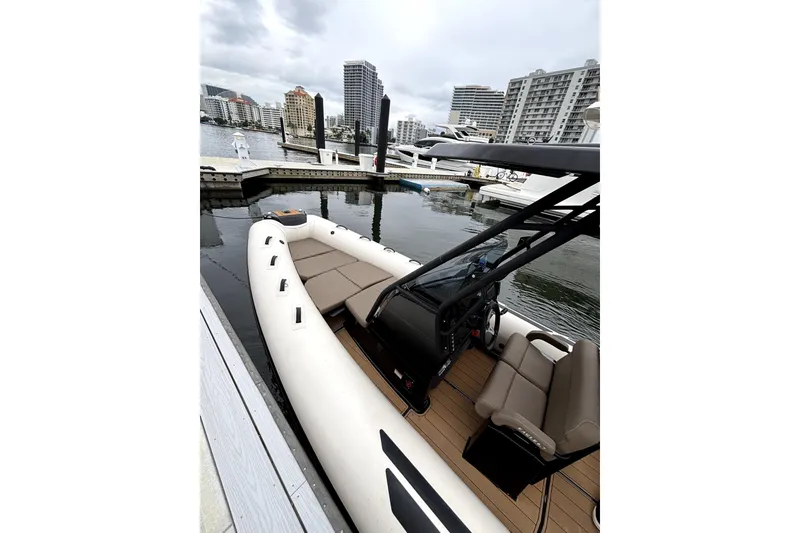 Slide: The Image of 2025 Brig NAVIGATOR22 boat docked at marina with city skyline in background. - 22