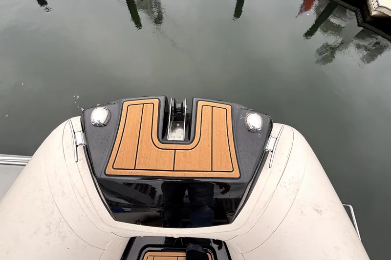 Slide: The Image of 2025 Brig NAVIGATOR22 boat bow with teak decking, docked on calm water. - 5