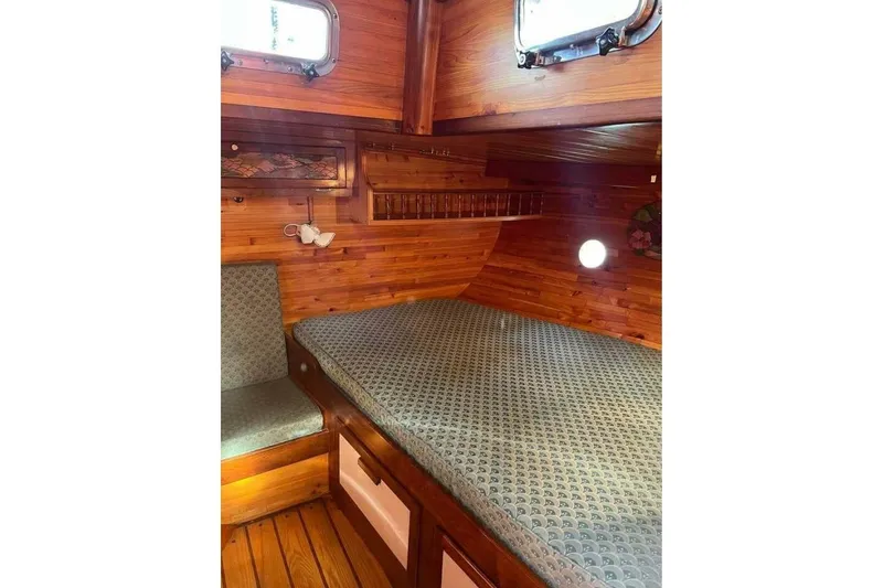 Slide: The Image of Cozy cabin interior of 1993 Custom Baraka 46 yacht with wooden paneling and patterned bedding. - 14