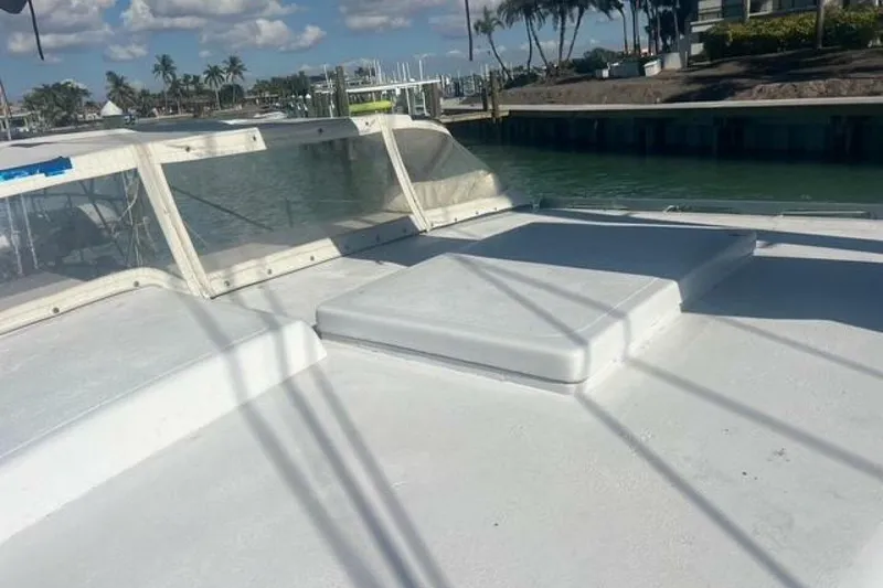 Slide: The Image of Custom Baraka 46 boat deck, 1993 model, docked near palm trees and water. - 22