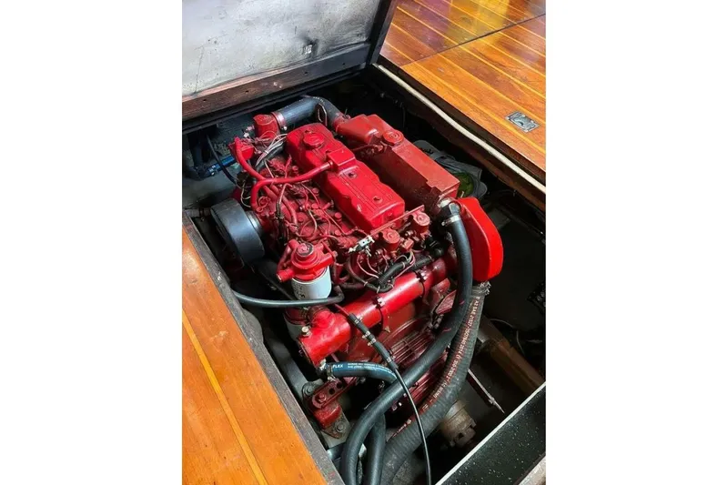Slide: The Image of Red engine of a 1993 Custom Baraka 46 boat, partially enclosed in wooden compartment. - 34