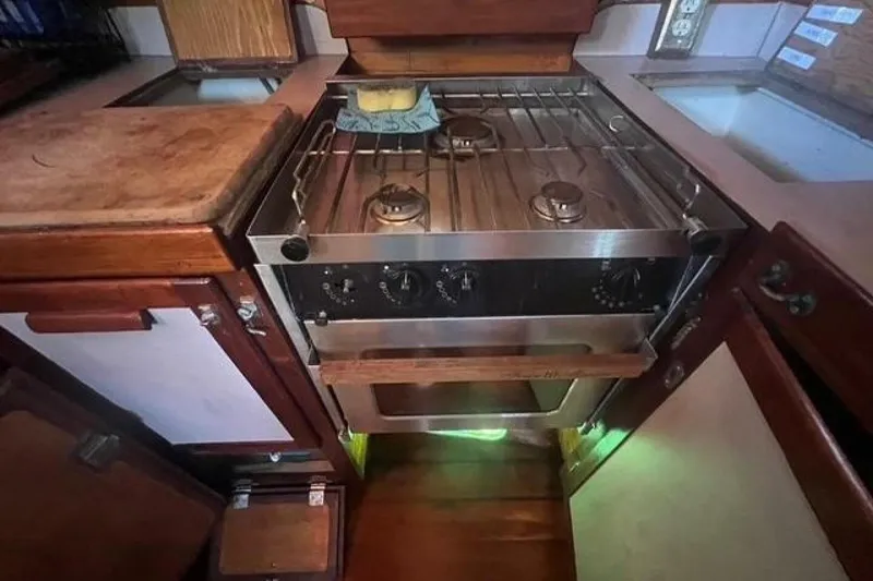 Slide: The Image of Compact kitchen with a stainless steel stove in a 1993 Custom Baraka 46 boat. - 7