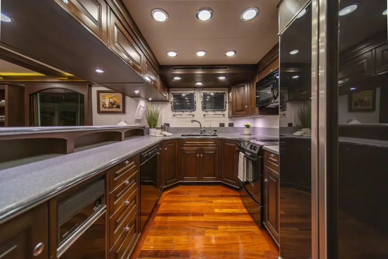 Slide: The Image of Luxurious kitchen interior of 2004 Northern Marine 80' Tri-Deck Expedition yacht, featuring elegant wood cabinetry. - 23