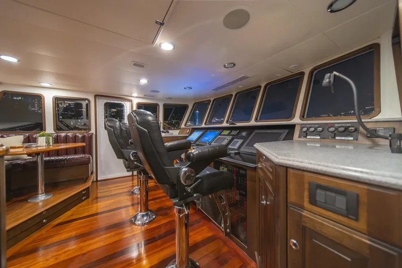 Slide: The Image of Luxurious helm of 2004 Northern Marine 80' Tri-Deck Expedition yacht with leather seating and wood flooring. - 28