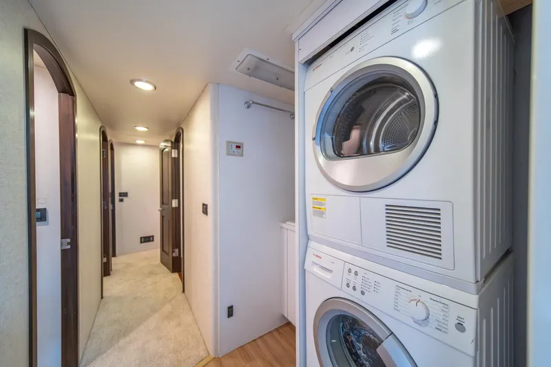 Slide: The Image of Laundry area in 2004 Northern Marine 80' Tri-Deck Expedition yacht, featuring stacked washer and dryer. - 52