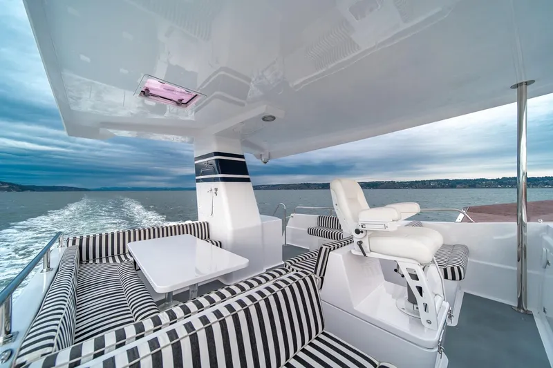Slide: The Image of Luxurious 2004 Northern Marine 80' Tri-Deck yacht with striped seating and ocean view. - 8