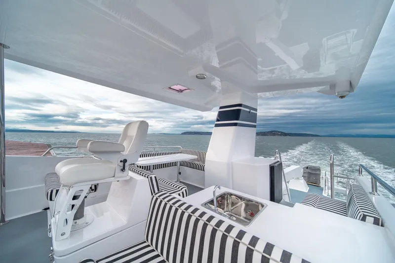Slide: The Image of Luxurious 2004 Northern Marine 80' Tri-Deck yacht with striped seating and ocean view. - 9