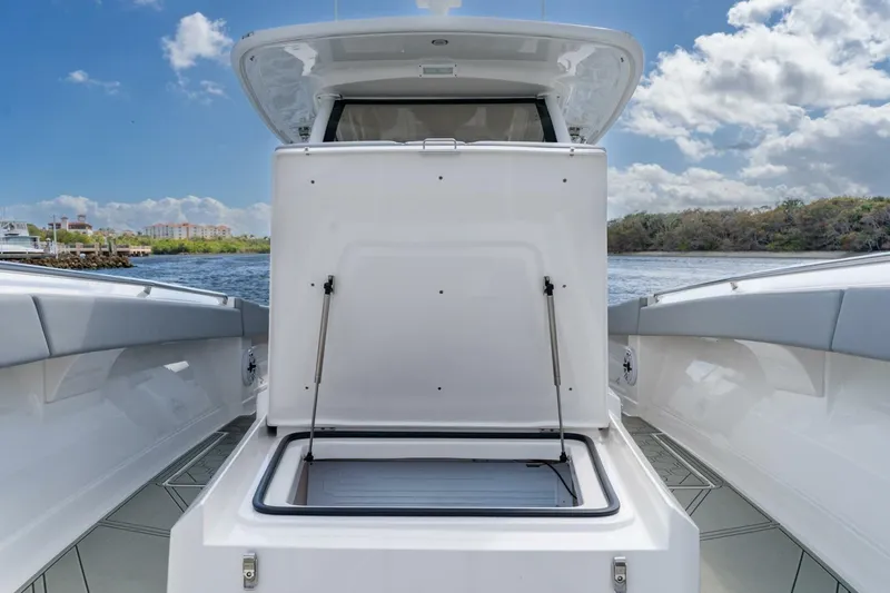 Slide: The Image of 2023 Blackwater High-Performance boat with open storage compartment, docked by scenic waterfront. - 24