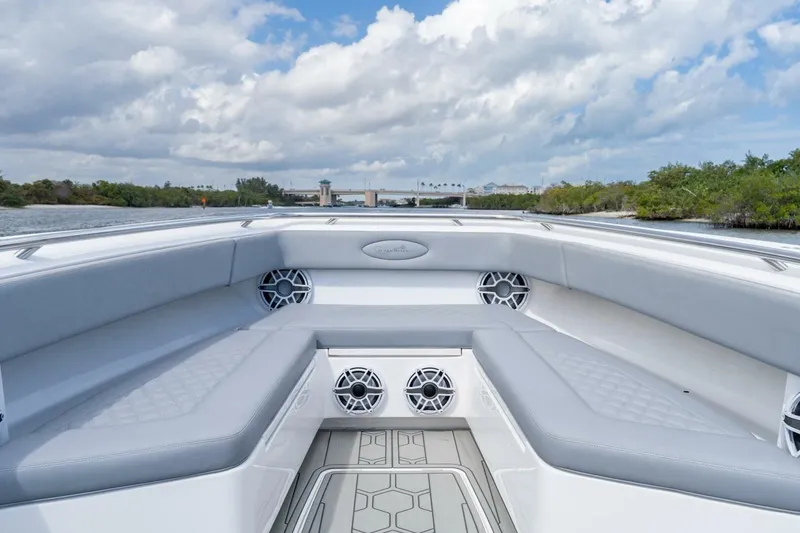Slide: The Image of 2023 Blackwater High-Performance boat interior with gray seating and speakers, under a cloudy sky. - 25