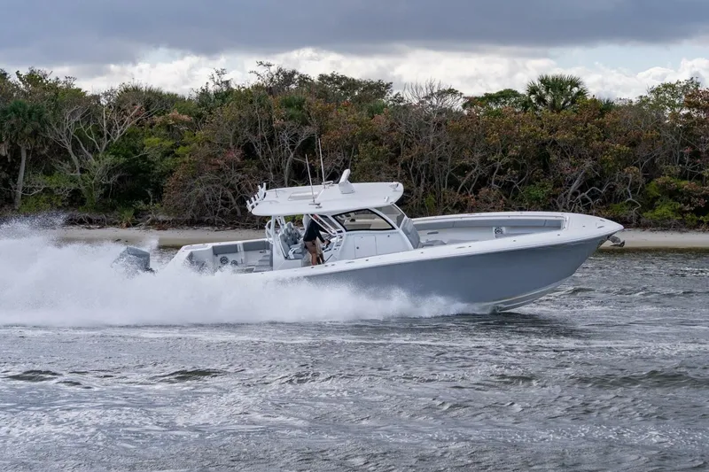 Slide: The Image of 2023 Blackwater High-Performance boat speeding on water near a forested shoreline. - 8