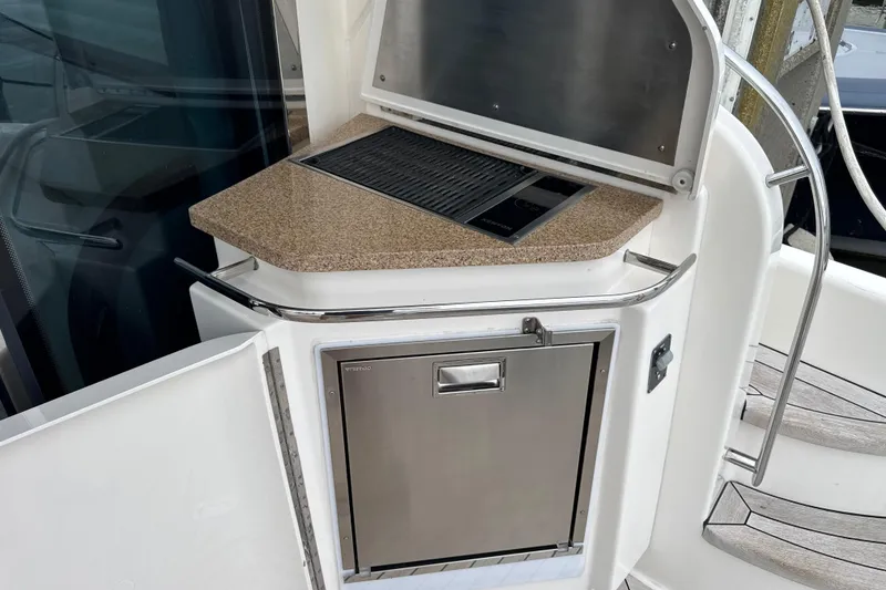 Slide: The Image of Outdoor kitchen on 2014 Tiara Yachts 5800 Sovran with grill and stainless steel fridge. - 15
