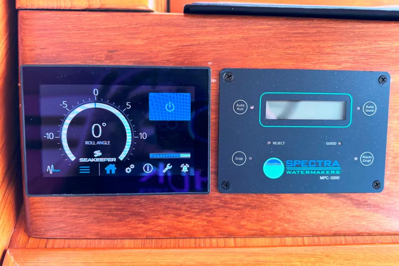 Slide: The Image of Control panel of a 2014 Tiara Yachts 5800 Sovran, featuring Seakeeper and Spectra Watermakers displays. - 29