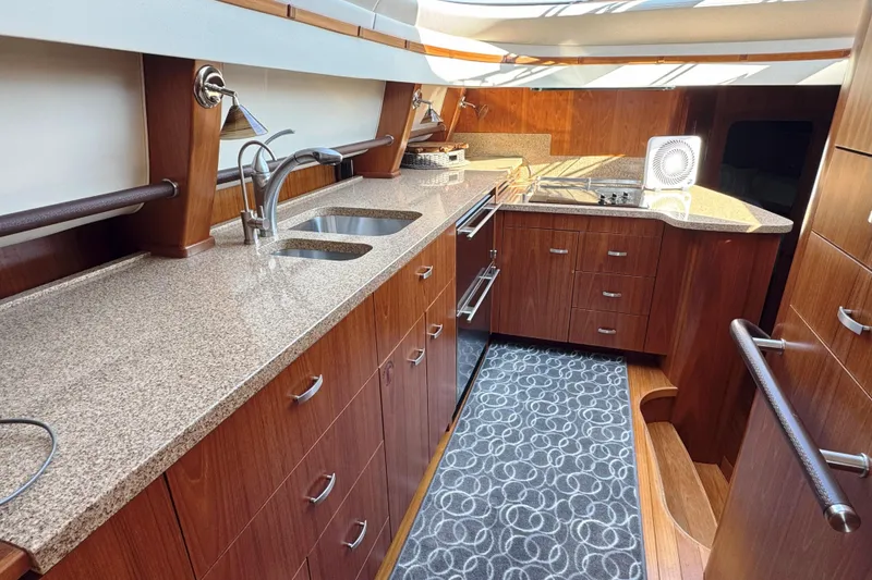 Slide: The Image of Luxurious 2014 Tiara Yachts 5800 Sovran kitchen with sleek wood cabinetry and modern appliances. - 34