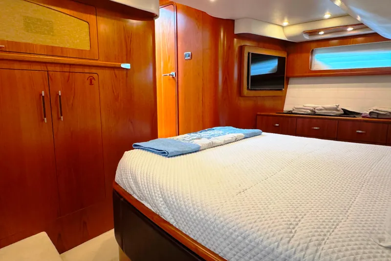 Slide: The Image of Luxurious cabin interior of 2014 Tiara Yachts 5800 Sovran with wood finishes and cozy bedding. - 40