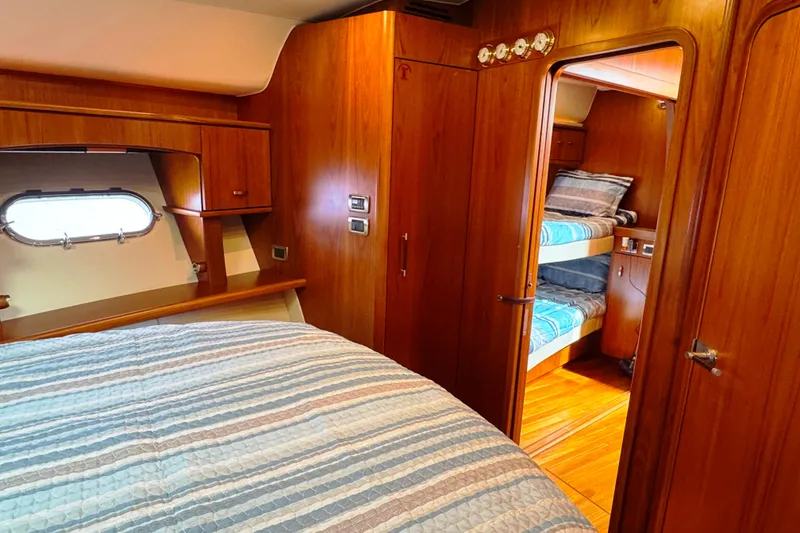 Slide: The Image of Luxurious 2014 Tiara Yachts 5800 Sovran cabin with wood interior and cozy bedding. - 49
