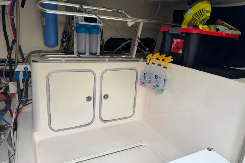 Slide: The Image of Engine room of 2014 Tiara Yachts 5800 Sovran with storage and cleaning supplies. - 64