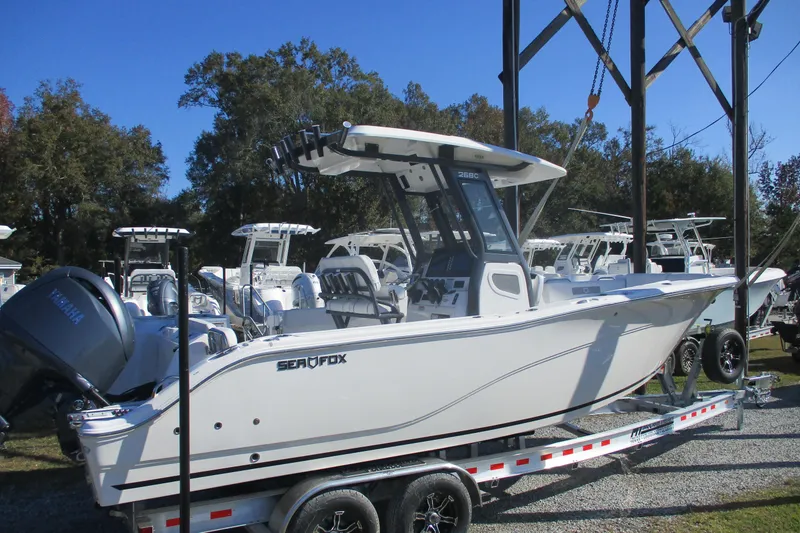Slide: The Image of 2026 Sea Fox 268 Commander boat on trailer, displayed outdoors under clear blue sky. - 1