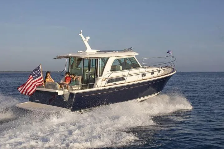 The Image of 2026 Sabre 38 yacht cruising on open water with passengers and American flag. - 1