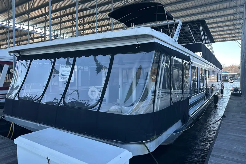 The Image of 1999 Sumerset 18x94 houseboat docked under covered marina, for sale sign visible. - 0